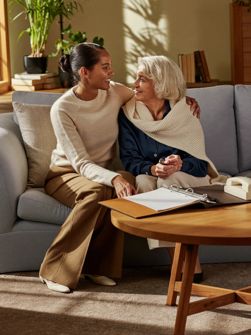 Illustration of a carer and older person reviewing paperwork at home