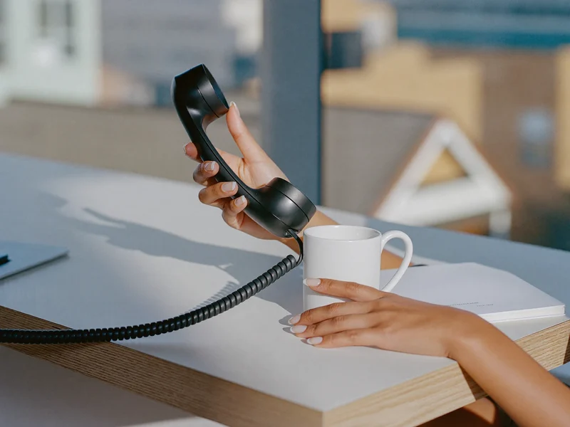 Illustration of a telephone handset and notepad suggesting remote advice